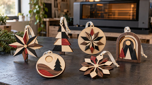 Finished batch of layered laser-cut wooden holiday ornaments on a maker workbench.