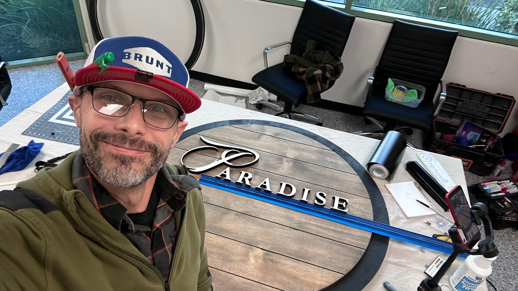 Man with a hat with ‘Brunt” on it working on a custom sign for paradise Chevrolet