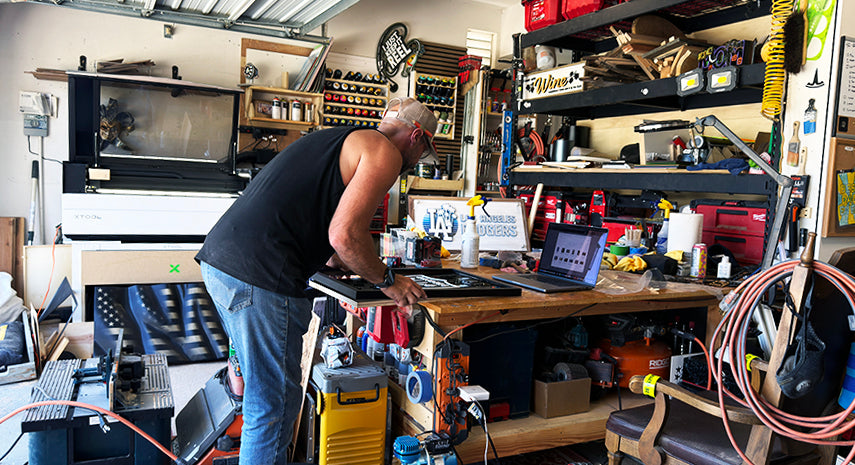 Person working in a cluttered workshop with tools and equipment.